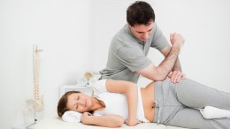 Doctor using his elbow to massage the hip of a woman
