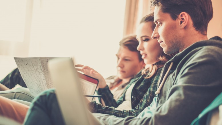 Three young students preparing for exams in apartment interior