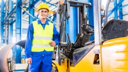 Forklift driver standing in manufacturing plant