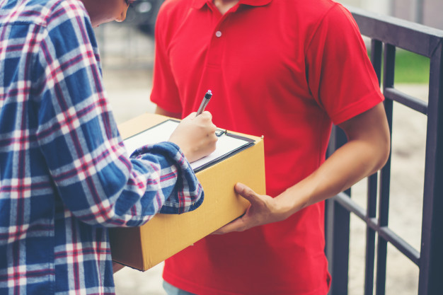 young-man-delivering-package-to-customer-at-home-delivery_1150-2963