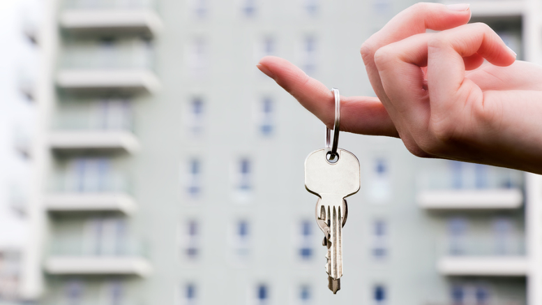 A real estate agent holding keys to a new apartment in her hands