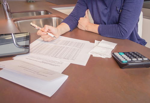 Unemployed and divorced woman with debts reviewing her monthly bills