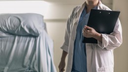 medical-professional-in-scrubs-holding-clipboard-and-pen