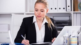 Successful businesswoman using laptop at workplace