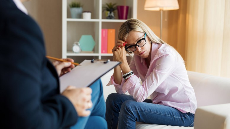 Young woman talking with psychotherapist